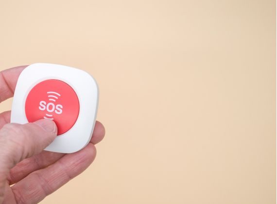 botão branco e vermelho com escrita SOS no centro